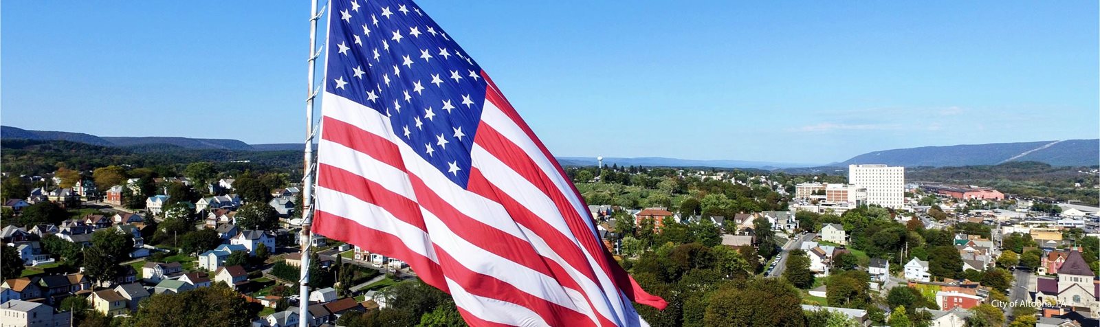 Gospel Hill Flag in front of city scape.