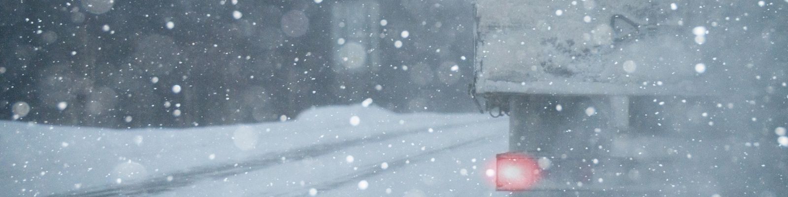 Picture showing a truck on a road going through a snow storm
