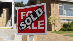 For sale sign with the word sold in front of it.