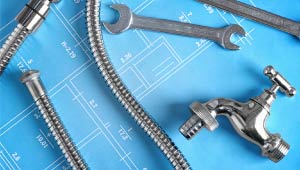 A picture of plumbing hardware over a blueprint.